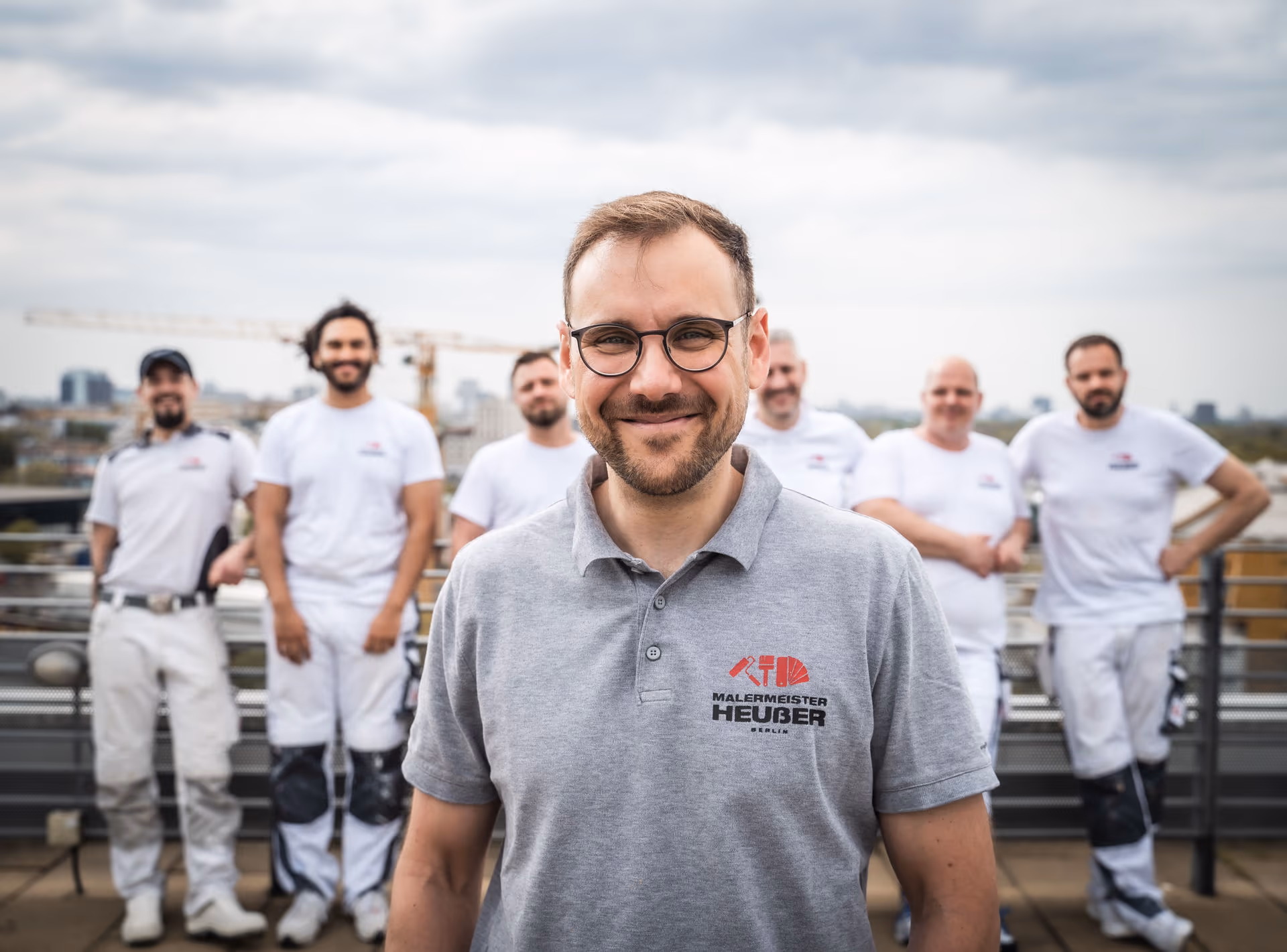 Malermeister Nicolai Heußer with his team on a rooftop in Berlin